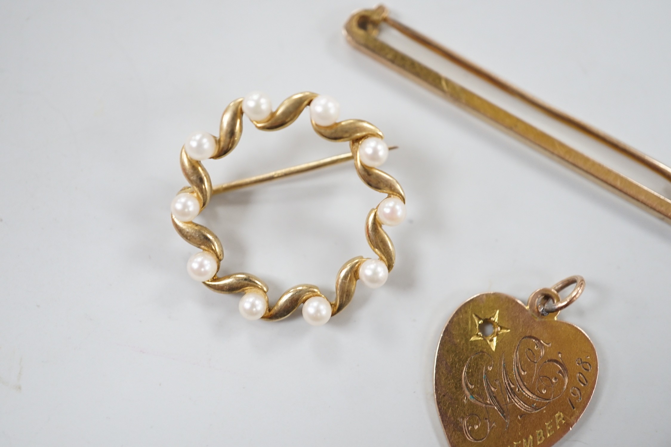 An Edwardian 9ct gold heart pendant (stone missing), 18mm, a yellow metal diablo charm and two brooches including 9ct bar brooch, gross weight 8.1 grams.